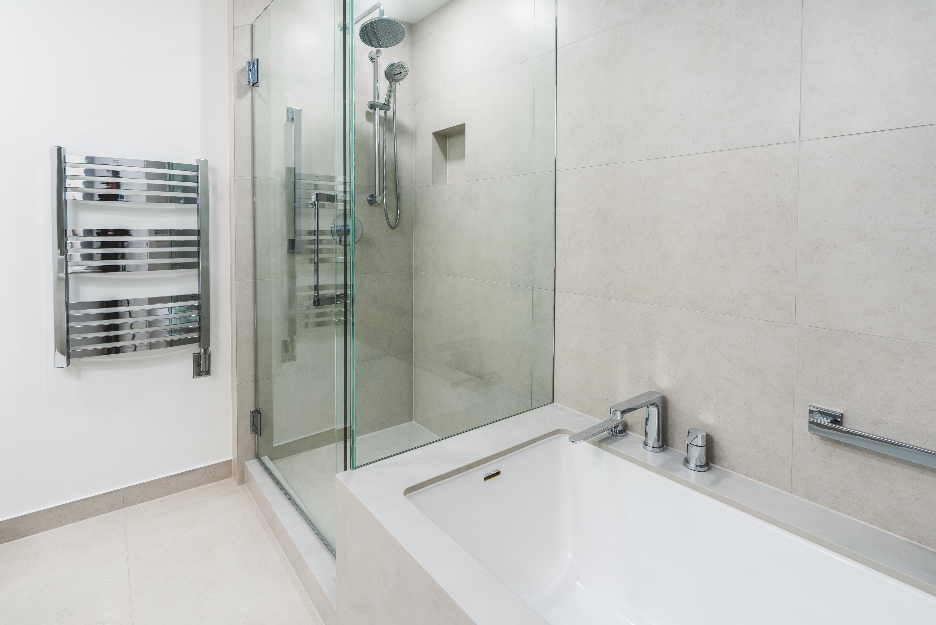 55-00-Modern Vancouver bathroom showcasing a glass walk-in shower, soaking tub, and chrome towel warmer rack.