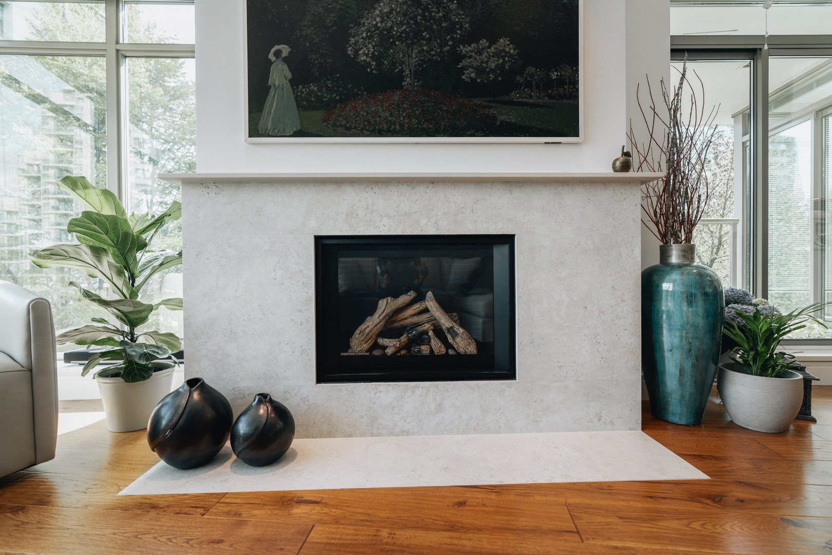 55-00-Close-up of a rustic stone fireplace with a log insert and green plants, Vancouver.