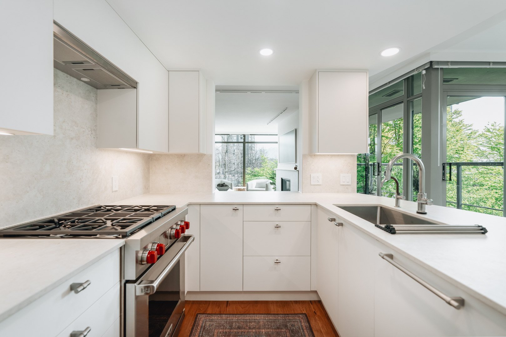 55-00-Modern white kitchen with premium gas range stove, stainless steel sink, and quartz counters, Vancouver.