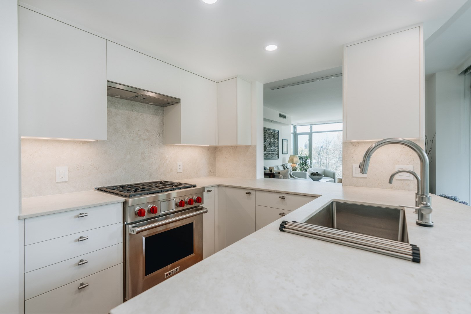 55-00-Sleek U-shaped white kitchen featuring custom cabinetry and under-cabinet task lighting, Vancouver.