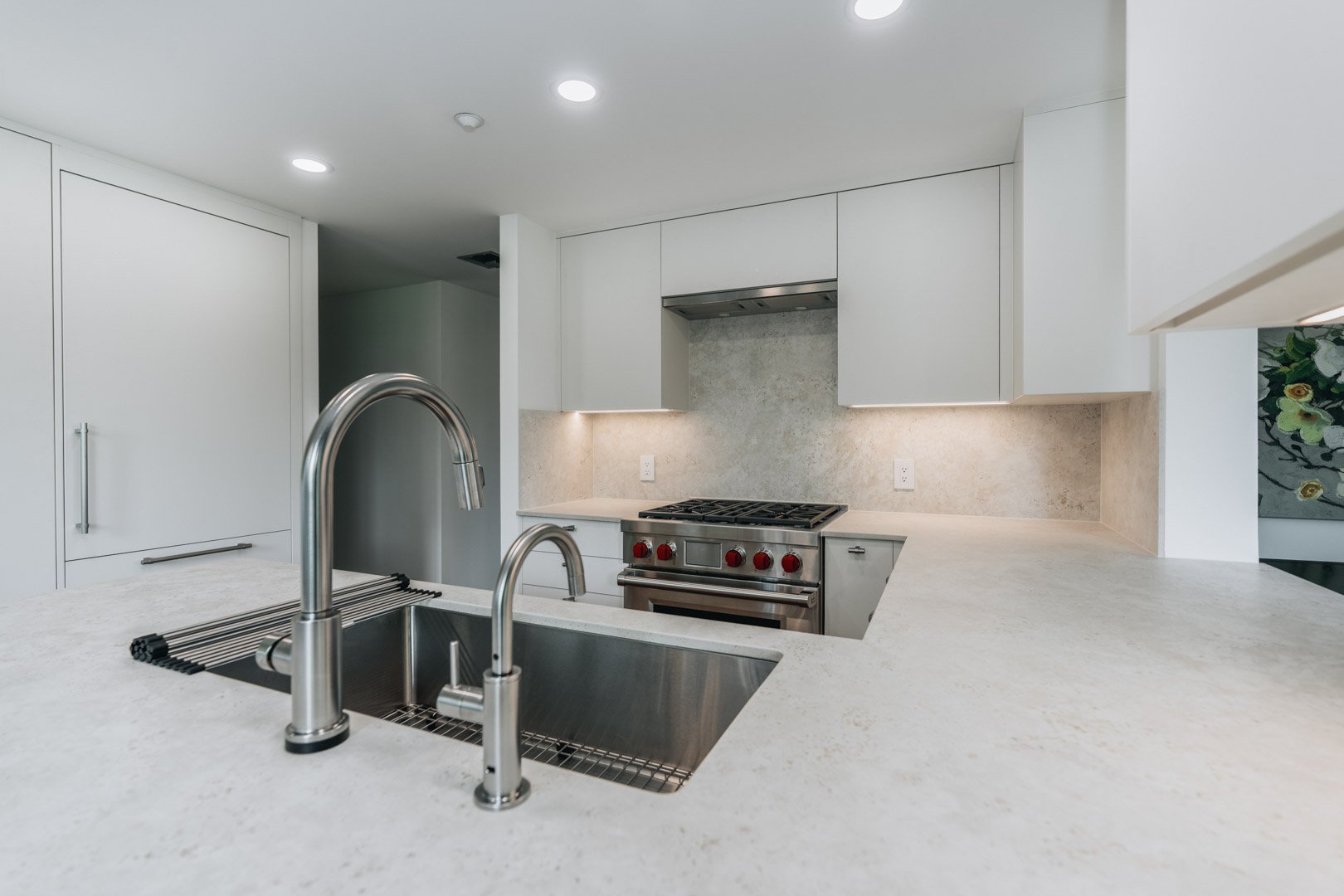 55-00-Close-up view of a stainless steel undermount kitchen sink on a white quartz island in Vancouver.