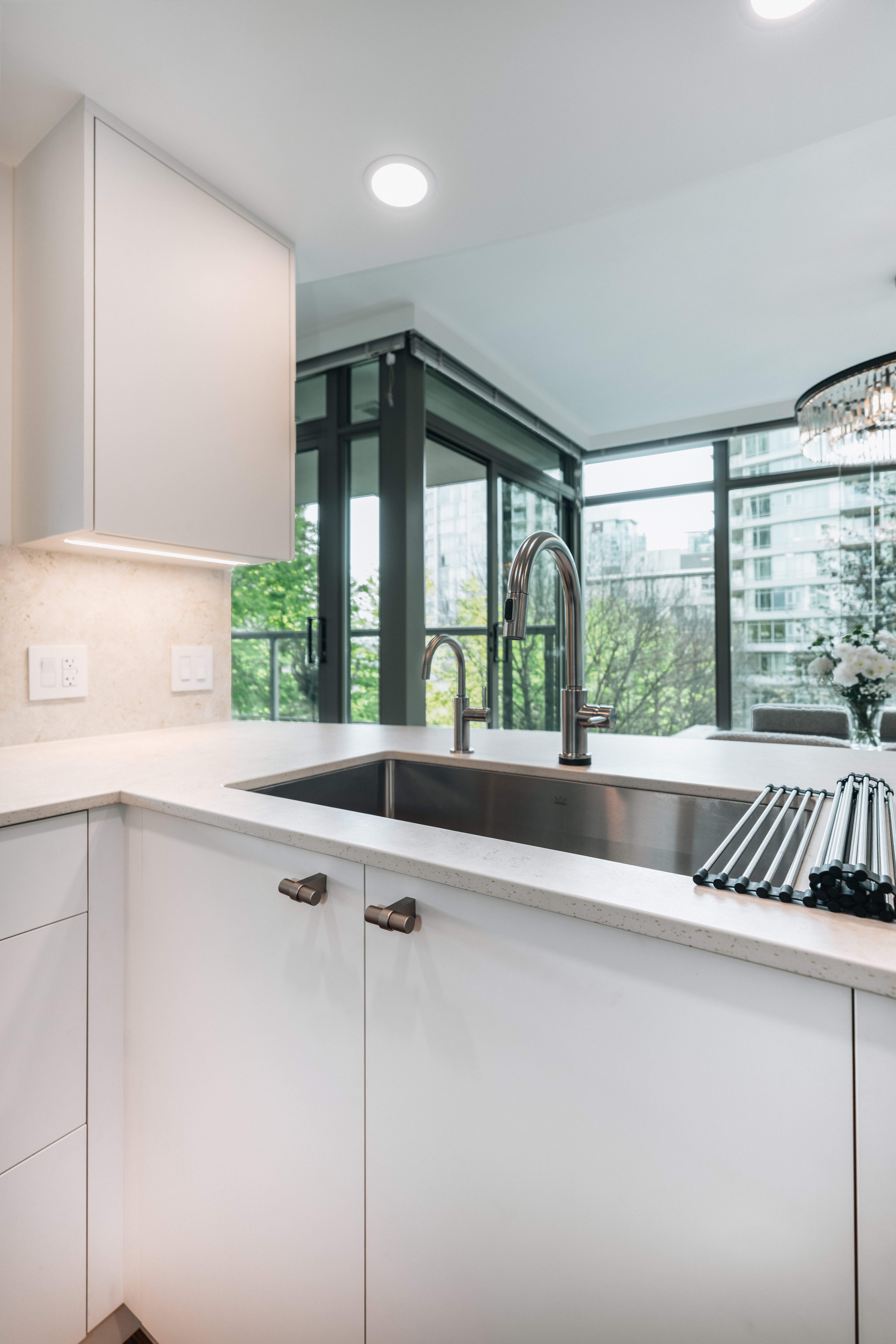 55-00-Stainless steel undermount kitchen sink and tall pull-down faucet with window views, Vancouver.
