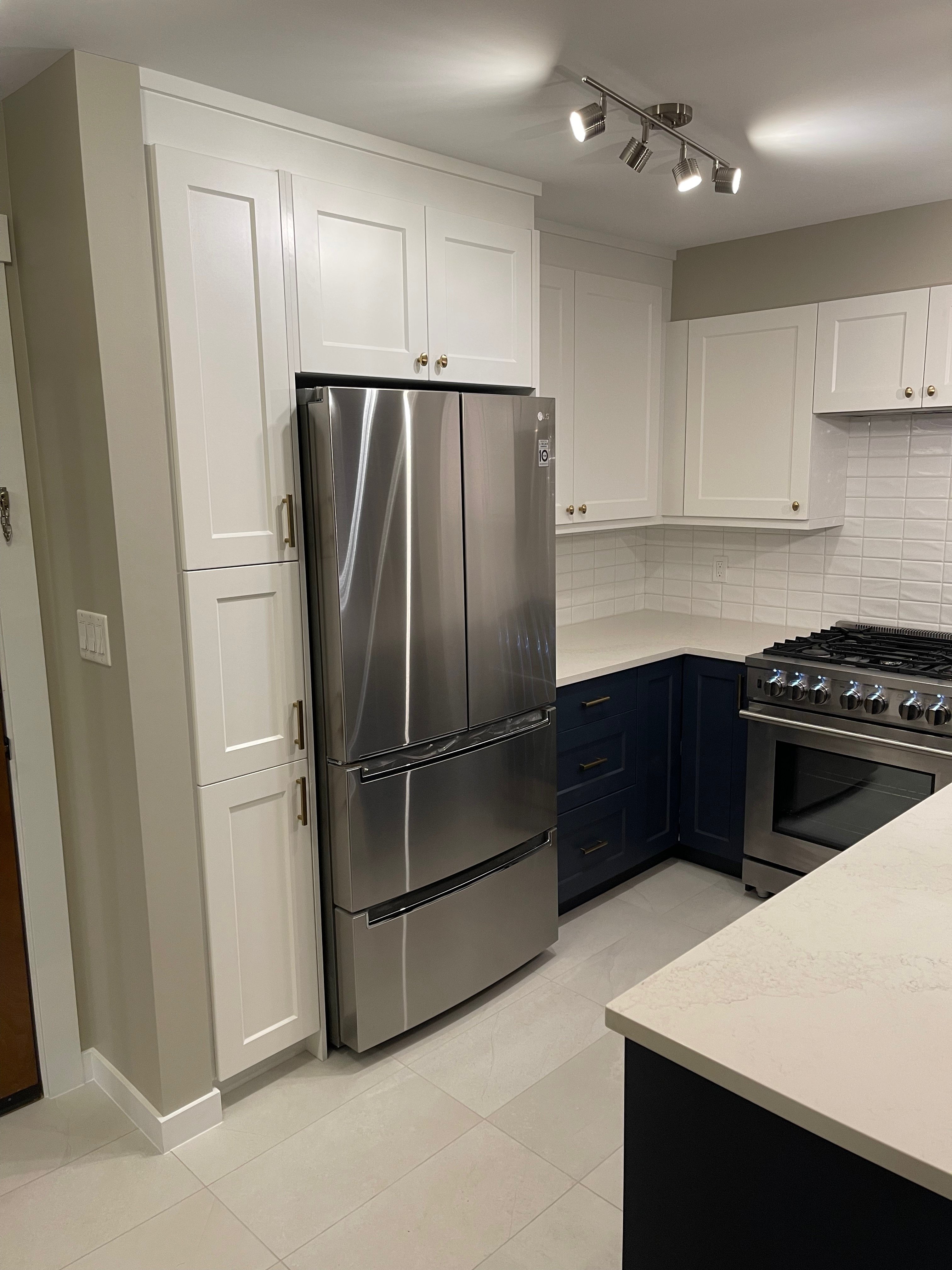 09-00-Two-tone Vancouver kitchen with white shaker cabinets, navy lowers, and large stainless steel fridge